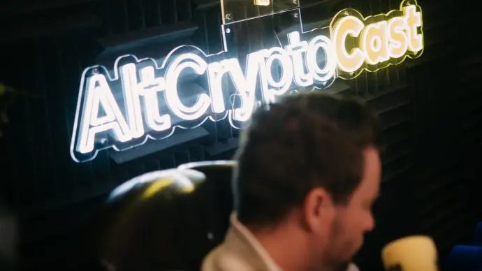 Sjuul voor een bord van zijn crypto podcast altcryptocast