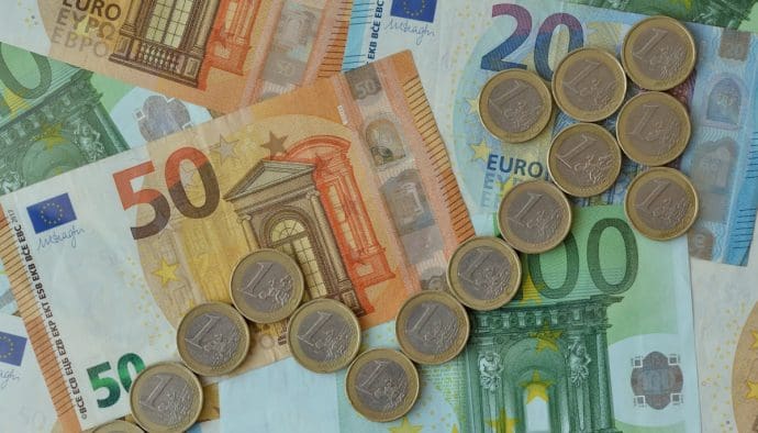 Een afbeelding met euro bankbiljetten en één euromunten die samen een stijgende pijl vormen