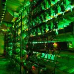 Een afbeelding van bitcoin miners die staan opgestapeld in een grote loods met groene verlichting