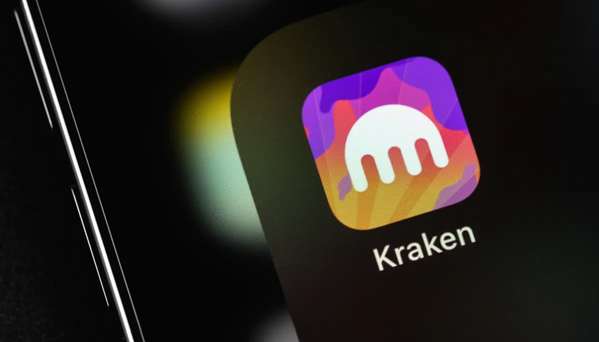 Een afbeelding van een IPhone met een kleurrijke app pictogram van cryptobeurs Kraken in een map