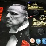 Een foto van verschillende cd's en verpakkingen van the godfather, een maffiafilm