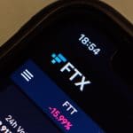 Het FTX logo te zien op een telefoon in de FTX app