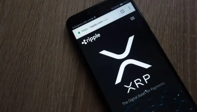 Foto van een mobiele telefoon met de website van Ripple geopend, met daarop het logo van XRP