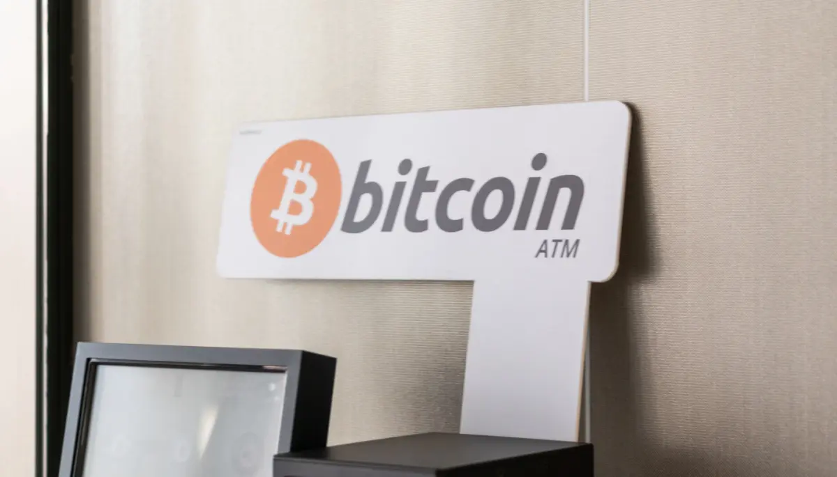 Bitcoin geldautomaat met scherm en bord met Bitcoin-logo en tekst ‘Bitcoin ATM’. Cryptocurrency opnamelocatie voor digitaal geld en blockchain-transacties